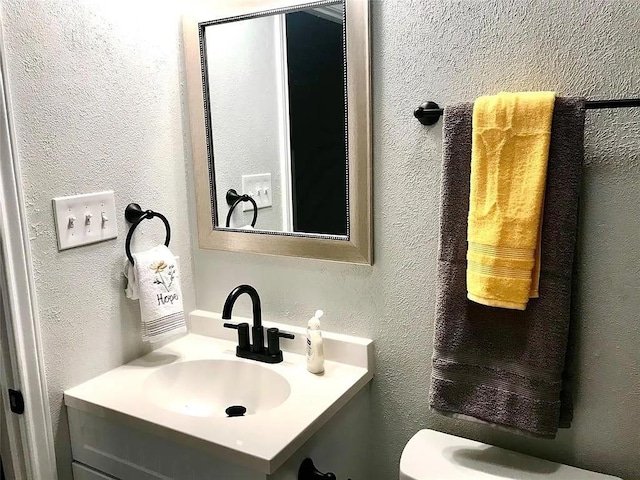 bathroom with vanity and a textured wall