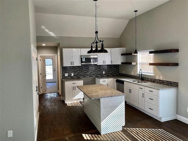 kitchen with open shelves, decorative backsplash, hanging light fixtures, stainless steel appliances, and a sink