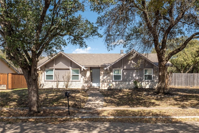 ranch-style home featuring fence and brick siding