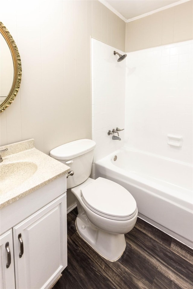 full bath with bathing tub / shower combination, wood finished floors, ornamental molding, and toilet