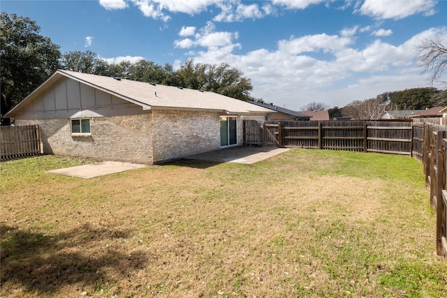 rear view of house with a fenced backyard and a yard