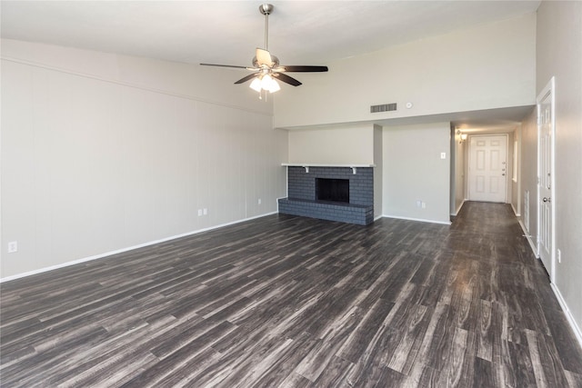 unfurnished living room featuring visible vents, dark wood-type flooring, a ceiling fan, a fireplace, and baseboards