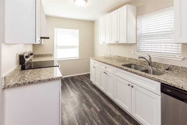 kitchen with dark wood finished floors, light stone counters, white cabinets, stainless steel appliances, and a sink