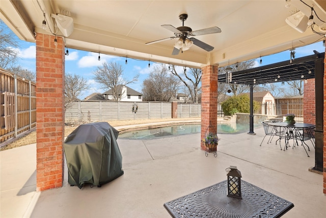 view of patio with grilling area, a fenced in pool, a ceiling fan, and a fenced backyard