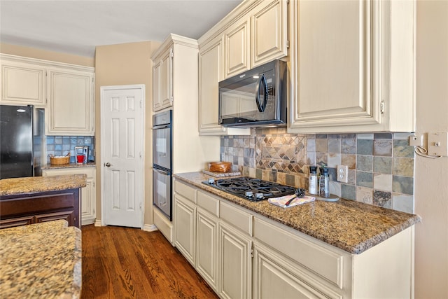 kitchen featuring black appliances, tasteful backsplash, light stone countertops, and dark wood-style flooring