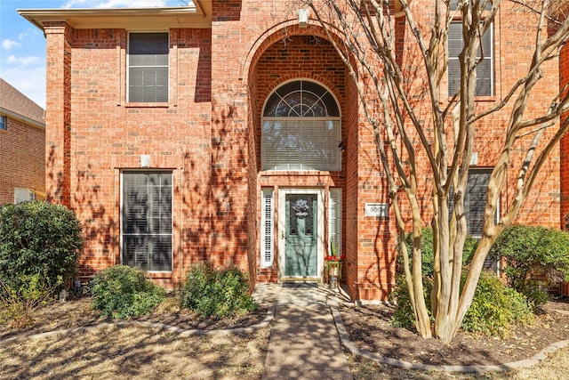 doorway to property featuring brick siding