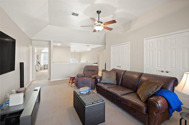 living area with visible vents, light carpet, baseboards, ceiling fan, and vaulted ceiling