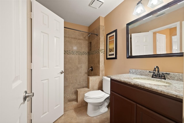 full bathroom with vanity, visible vents, a tile shower, tile patterned floors, and toilet