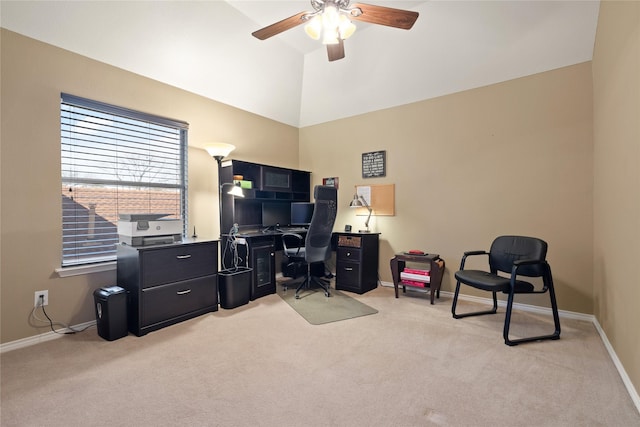 office space featuring vaulted ceiling, light colored carpet, baseboards, and ceiling fan