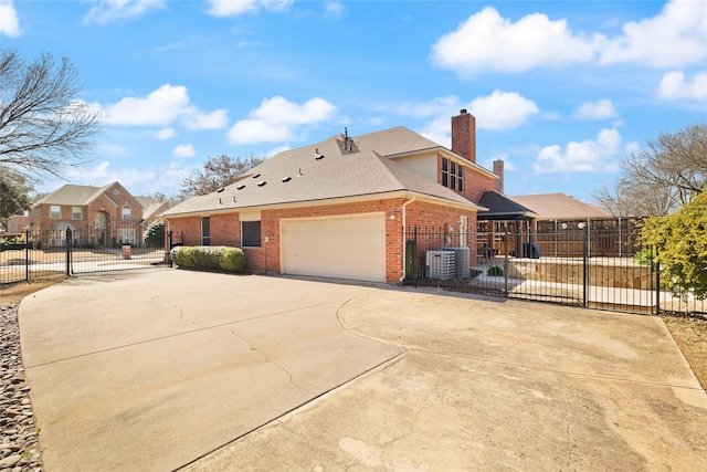 view of side of property featuring brick siding, fence, a chimney, driveway, and a gate