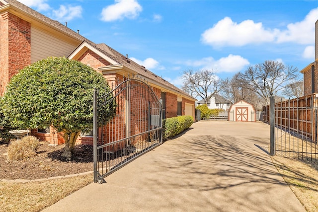 exterior space featuring brick siding, fence, and a gate