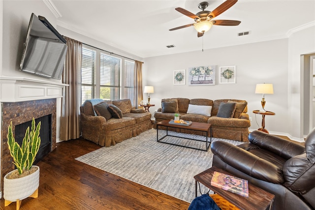 living area featuring visible vents, a fireplace, wood finished floors, and ornamental molding