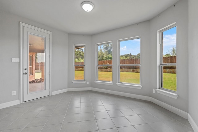 empty room with light tile patterned floors and baseboards