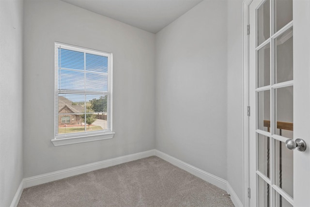 empty room featuring carpet and baseboards