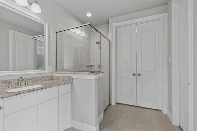 full bathroom featuring tile patterned floors, a stall shower, recessed lighting, baseboards, and vanity