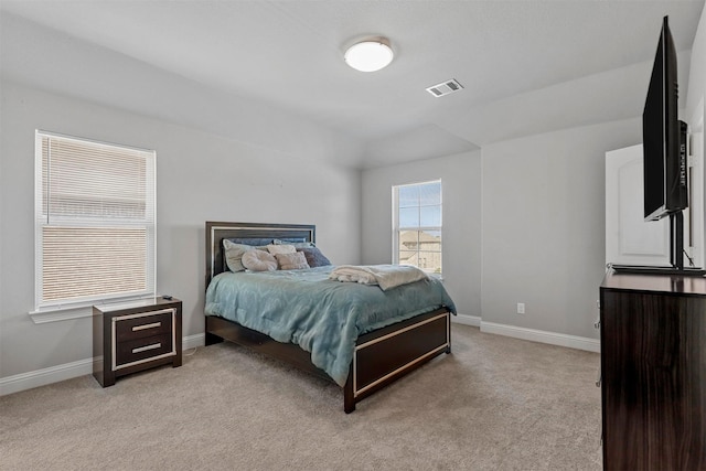 bedroom with visible vents, light colored carpet, and baseboards