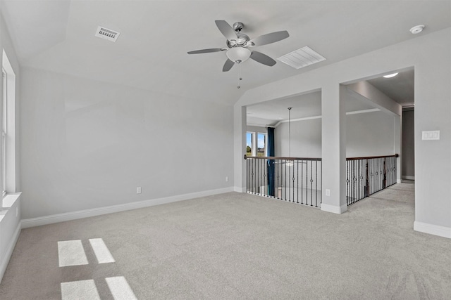 empty room with visible vents, ceiling fan, baseboards, lofted ceiling, and carpet floors