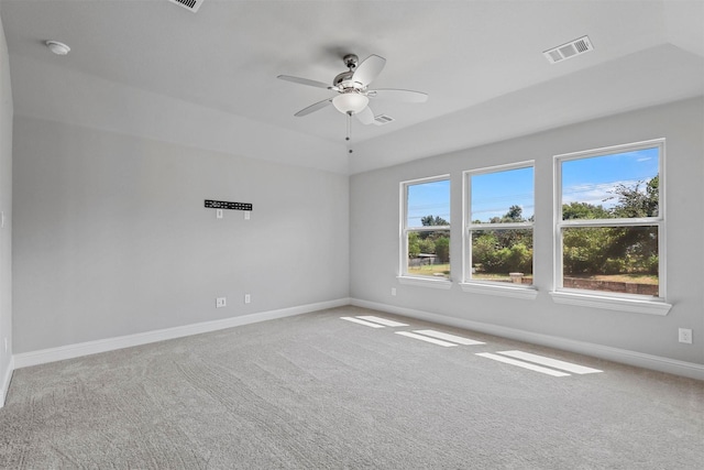 carpeted empty room with visible vents, a ceiling fan, and baseboards