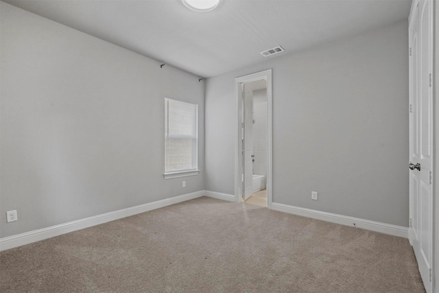 empty room with visible vents, light carpet, and baseboards