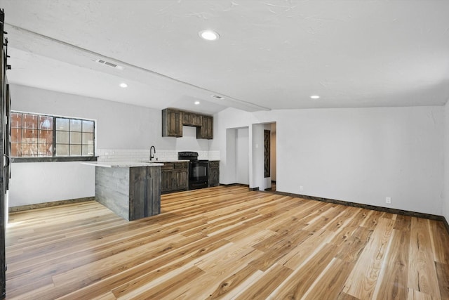 kitchen with visible vents, light wood-type flooring, black electric range, a peninsula, and light countertops