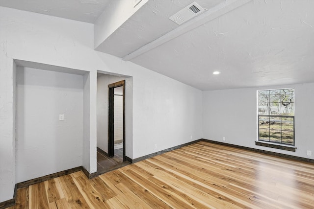 unfurnished room featuring visible vents, baseboards, and light wood-style floors