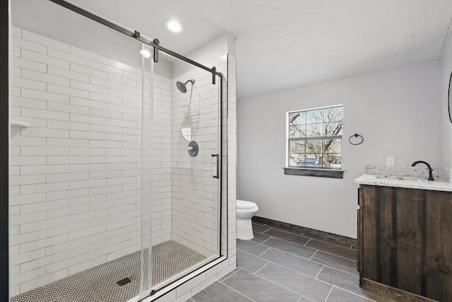 full bath with a stall shower, toilet, vanity, and baseboards