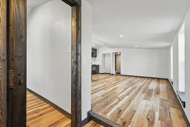 interior space with recessed lighting, light wood-type flooring, baseboards, and lofted ceiling