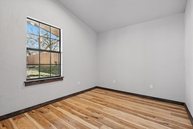 spare room featuring baseboards and wood-type flooring