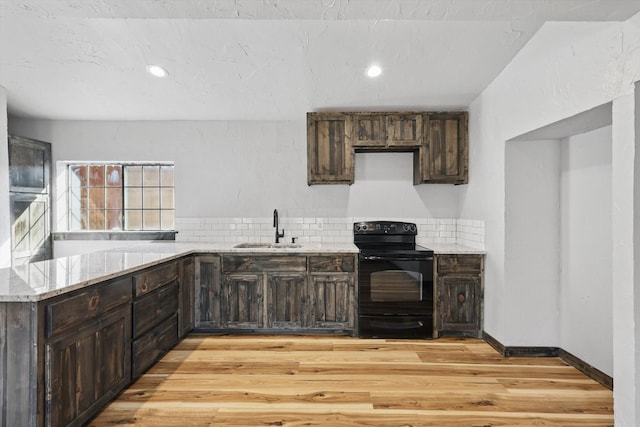 kitchen with light stone counters, a sink, dark brown cabinets, black range with electric stovetop, and light wood-style floors