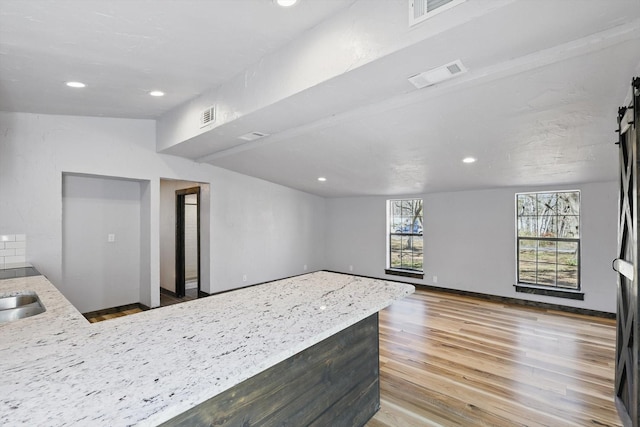 interior space featuring recessed lighting, visible vents, a peninsula, and wood finished floors