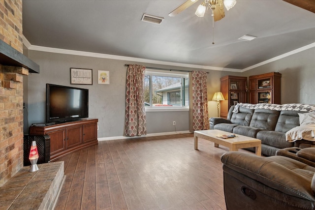 living area featuring visible vents, baseboards, ornamental molding, and dark wood-style flooring