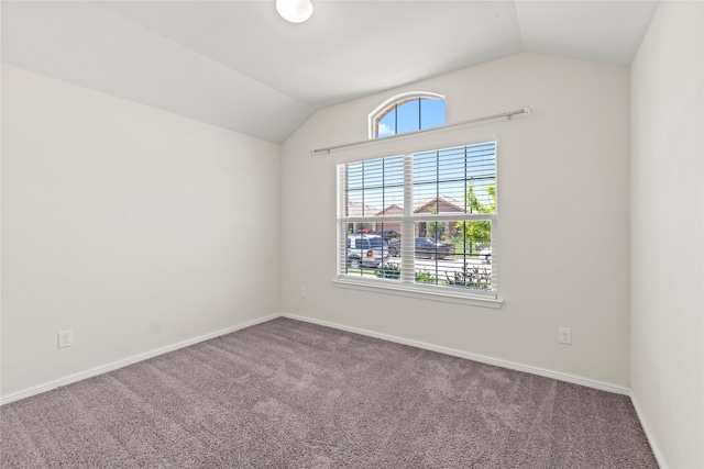 unfurnished room featuring baseboards, carpet, and vaulted ceiling