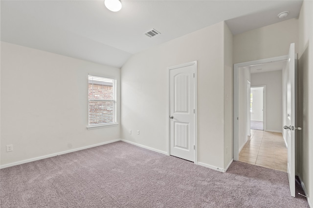 unfurnished room featuring visible vents, baseboards, lofted ceiling, and carpet floors