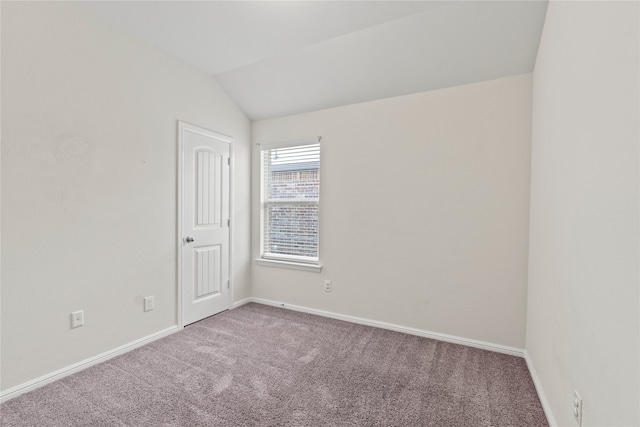 unfurnished room featuring vaulted ceiling, carpet flooring, and baseboards