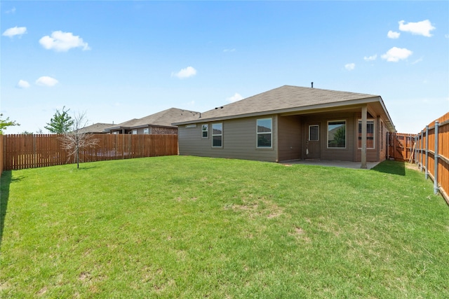 rear view of property with a yard, a patio, and a fenced backyard