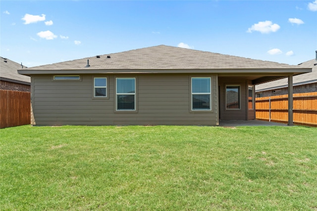 rear view of property with a patio area, a yard, and fence