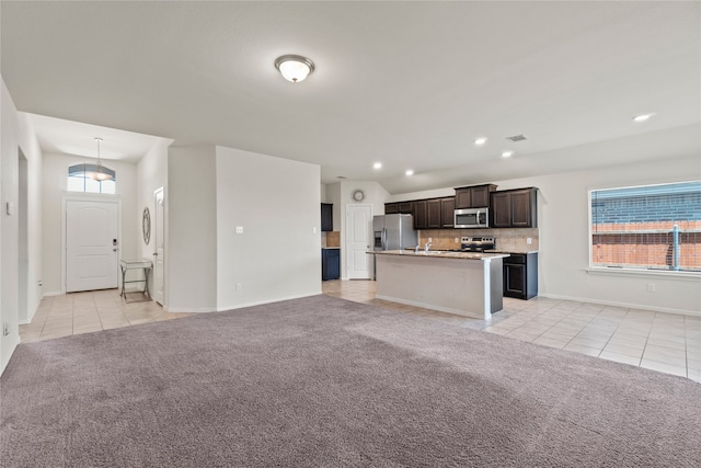 unfurnished living room featuring light tile patterned floors, light colored carpet, recessed lighting, and baseboards