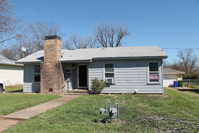 view of front facade with a front lawn, cooling unit, a detached garage, and a chimney