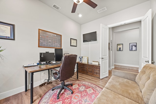 home office featuring visible vents, a ceiling fan, baseboards, and wood finished floors