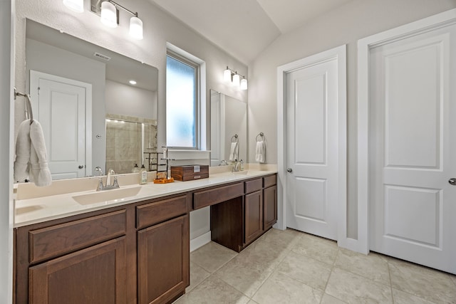 bathroom with a shower stall, double vanity, and a sink