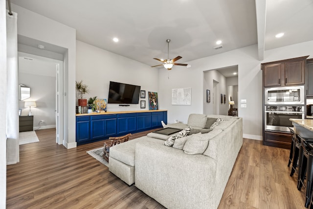 living room with recessed lighting, wood finished floors, visible vents, and baseboards