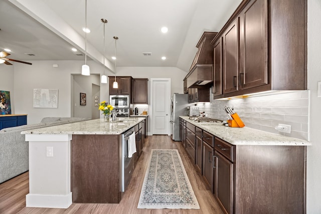 kitchen featuring visible vents, dark brown cabinets, open floor plan, appliances with stainless steel finishes, and a sink