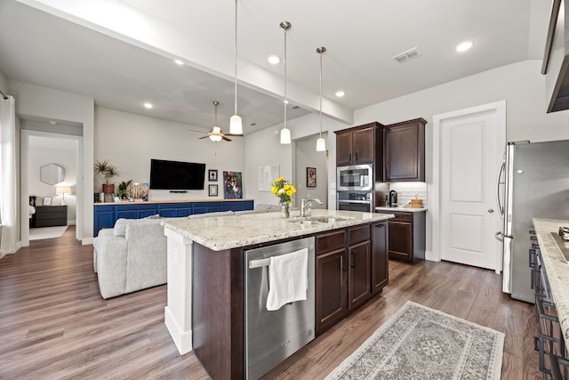 kitchen with visible vents, a sink, open floor plan, stainless steel appliances, and dark brown cabinetry