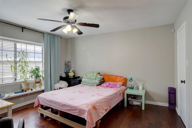 bedroom with ceiling fan, baseboards, and wood finished floors