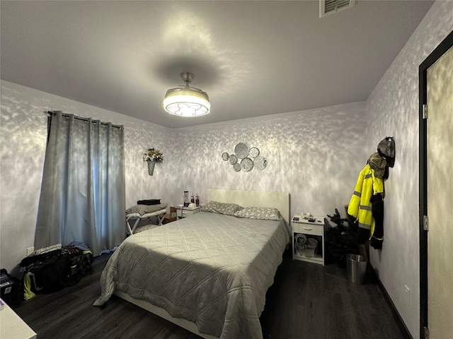 bedroom with visible vents, wood finished floors, and wallpapered walls