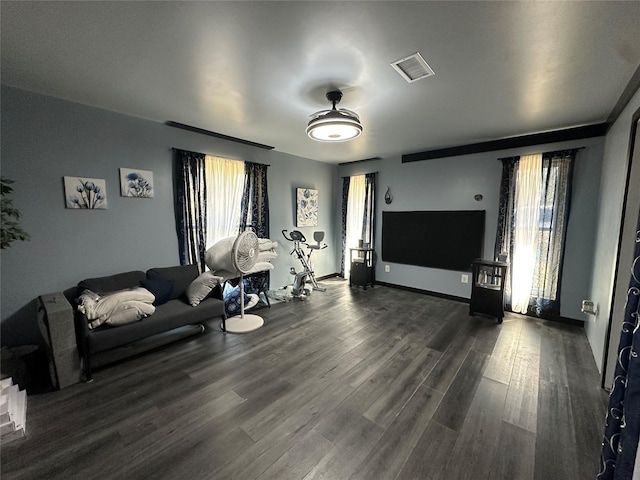 living room with visible vents, baseboards, and dark wood-style floors