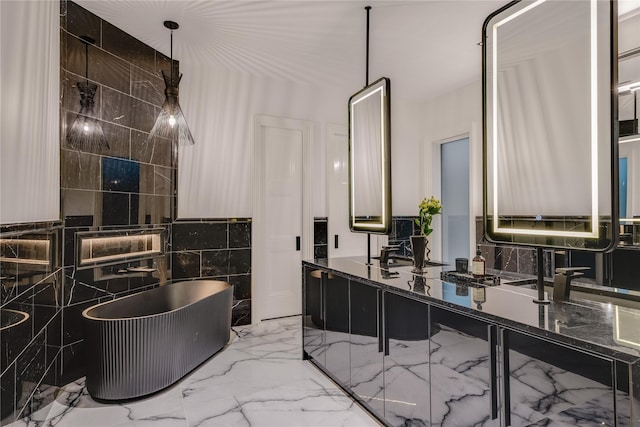 bathroom featuring double vanity, a freestanding tub, and marble finish floor