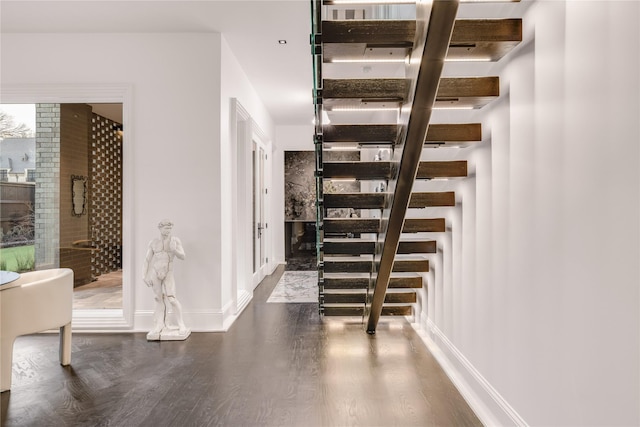 staircase with baseboards and wood finished floors