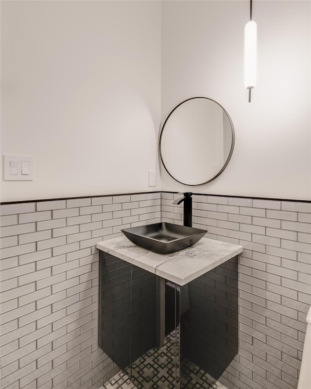6404 Lakehurst Ave, Dallas, TX 75230 - bathroom featuring tile walls, a sink, and wainscoting