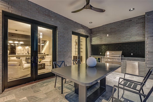 dining area featuring a ceiling fan, french doors, and brick wall